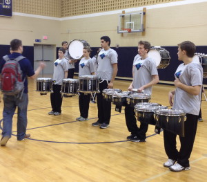 Unionville High Drumline Coach Cody Stafford (left) gives his musicians instruction before a recent performance.