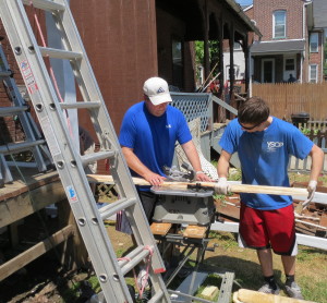 Scott Bowman (from left) and Tyler Changaris cut new fence boards for Jones'  front yard.
