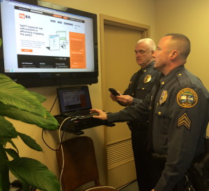 Coatesville Police Chief Jack Laufer (left) and Sgt. Rodger Ollis demonstrate the ease with which citizens can contact police anonymously through a phone app.