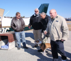 Pilot Matt Kiener (from left), Chester County SPCA spokesman Rich Britton, Chester County SPCA Animal Protective Services Officer Craig Baxter and Chester County SPCA Operations Manager Mike Dempsey get ready to put Radar in his crate for the plane ride.
