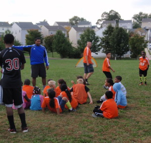 J.T. Dorsey (blue shirt) instructs a group of young soccer players at Milview Park.