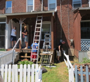 A group of volunteers work to make a home in the unit block of North Eighth Avenue less inviting to vandals.