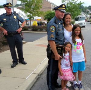 As Coatesville Police Chief Jack Laufer (left) looks on, Sgt. Rodger Ollis Jr. poses with his wife, Michele, and daughters 