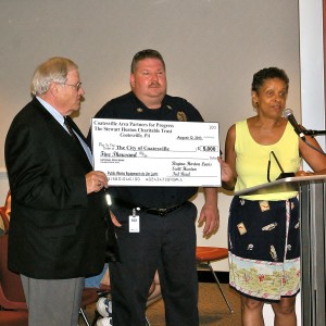 CAPP member Ted Reed (left) and Chairperson Regina Horton Lewis (right) present Acting Fire Chief James Lentz with  a $5,000 check. The grant from the Stewart Huston Charitable Trust will be used to purchase new barricades.