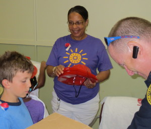 Pam Lewis (center), who directs the Coatesville Memorial Community Camp, and Firefighter Craig Weaver hand out hats and t-shirts to the "Fire Safety Camp" participants.