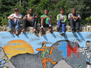 The ServiceCorps crew takes a moment to relax after finishing a mural that depicts the Waste Oil Recyclers employees as "superheroes."