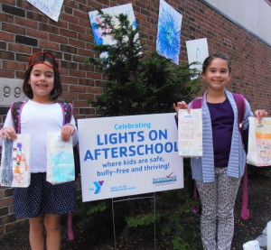 Two girls from the YMCA of the Brandywine Valley after-school program proudly display the luminary bags they created for the National initiative, “Lights on Afterschool.” This year’s event will take place on Thursday.