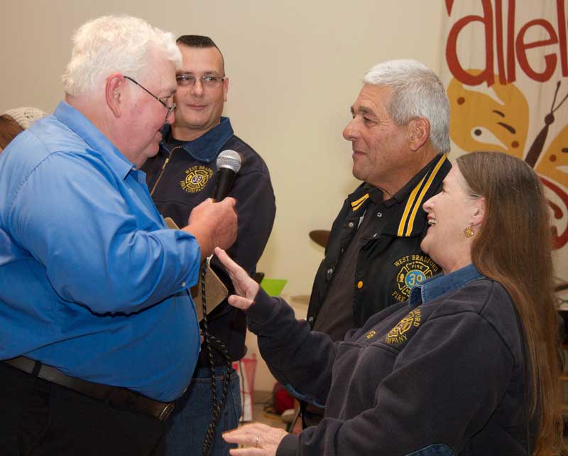 Master of Ceremonies Del Bittle shares a moment with firefighters from the West Bradford Fire Company, during a special event Saturday to honor local volunteer firefighters.