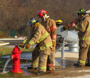 As her colleagues watch, Hayleigh Hunter, 17, of Avon Grove High, drains the fire hydrant so that the hose can be attached.