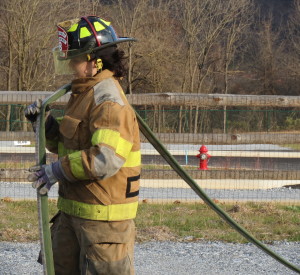 Jordan Ganler straightens out a hose so that it can be rolled up.