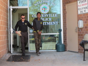 Coatesville Det./Sgt. Brandon Harris escorts Christopher P. Howard to an awaiting police car for his arraignment on robbery charges.