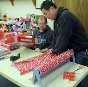 Wayne Welty (left), an assistant  leader of Troop 41365 works with West Caln Sgt. Christopher Fries on wrapping.