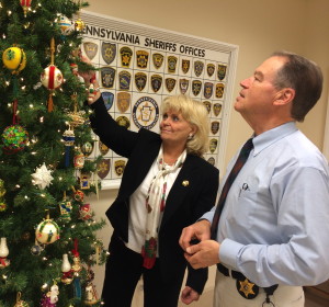 Chester County Sheriff Carolyn “Bunny” Welsh and Chief Deputy Sheriff George P. March scan the tree for their favorite ornaments from a collection handcrafted by March’s mother, Alice March, who died in September.