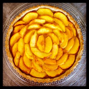 Whether artfully arranged in a tart as shown here, made into a crumble or served warm in a pie, baked peaches make for summer delicacies.  Photo courtesy of Simona Carini